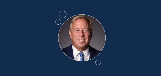 burt zweigenhaft in a suit and tie smiles for a portrait.