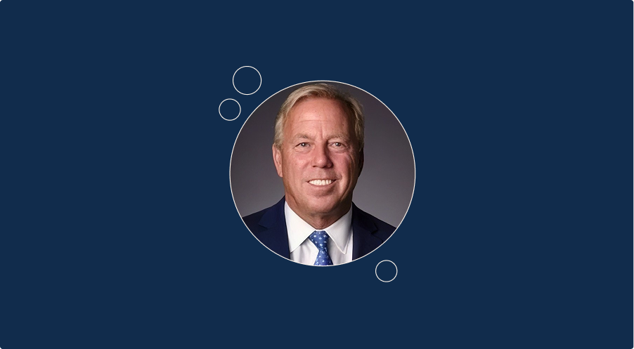 burt zweigenhaft in a suit and tie smiles for a portrait.